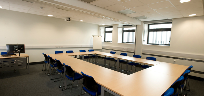 Classroom with tables and chairs in boardroom layout